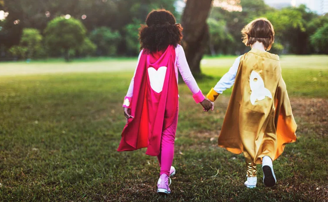 Children in superhero costumes walking hand-in-hand